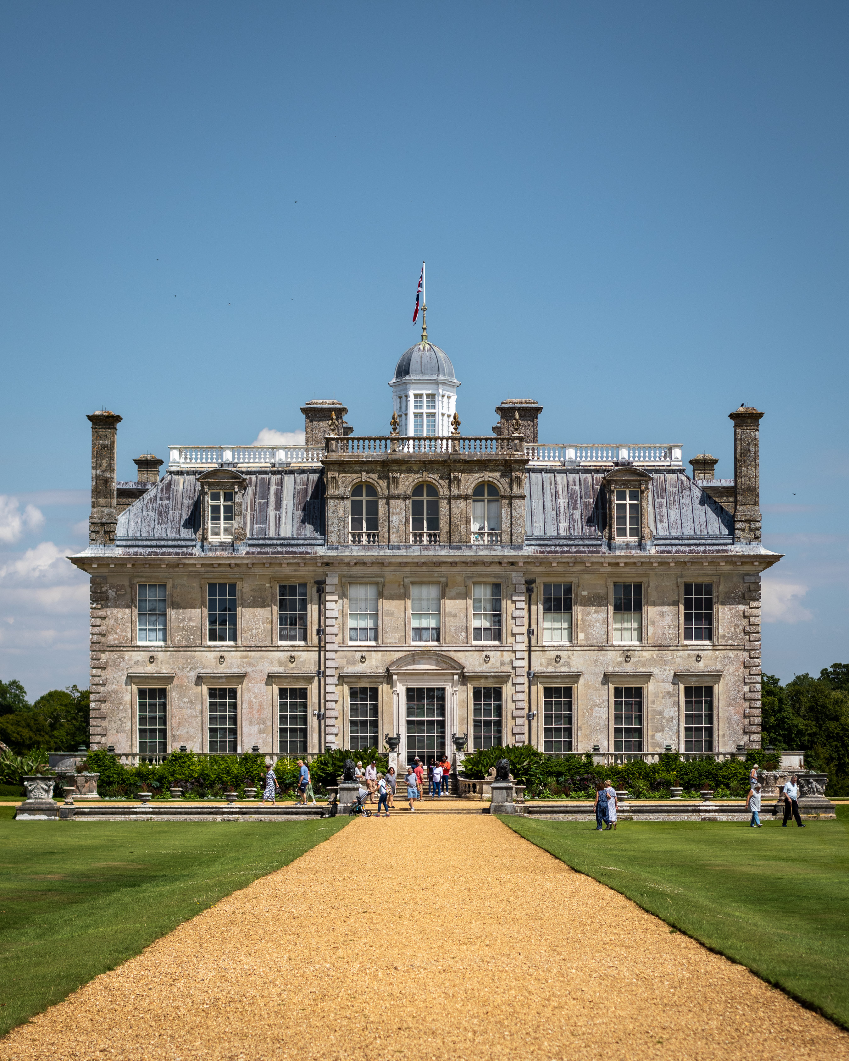 Kingston Lacy stately home seen down its long gravel drive on a bright summer day