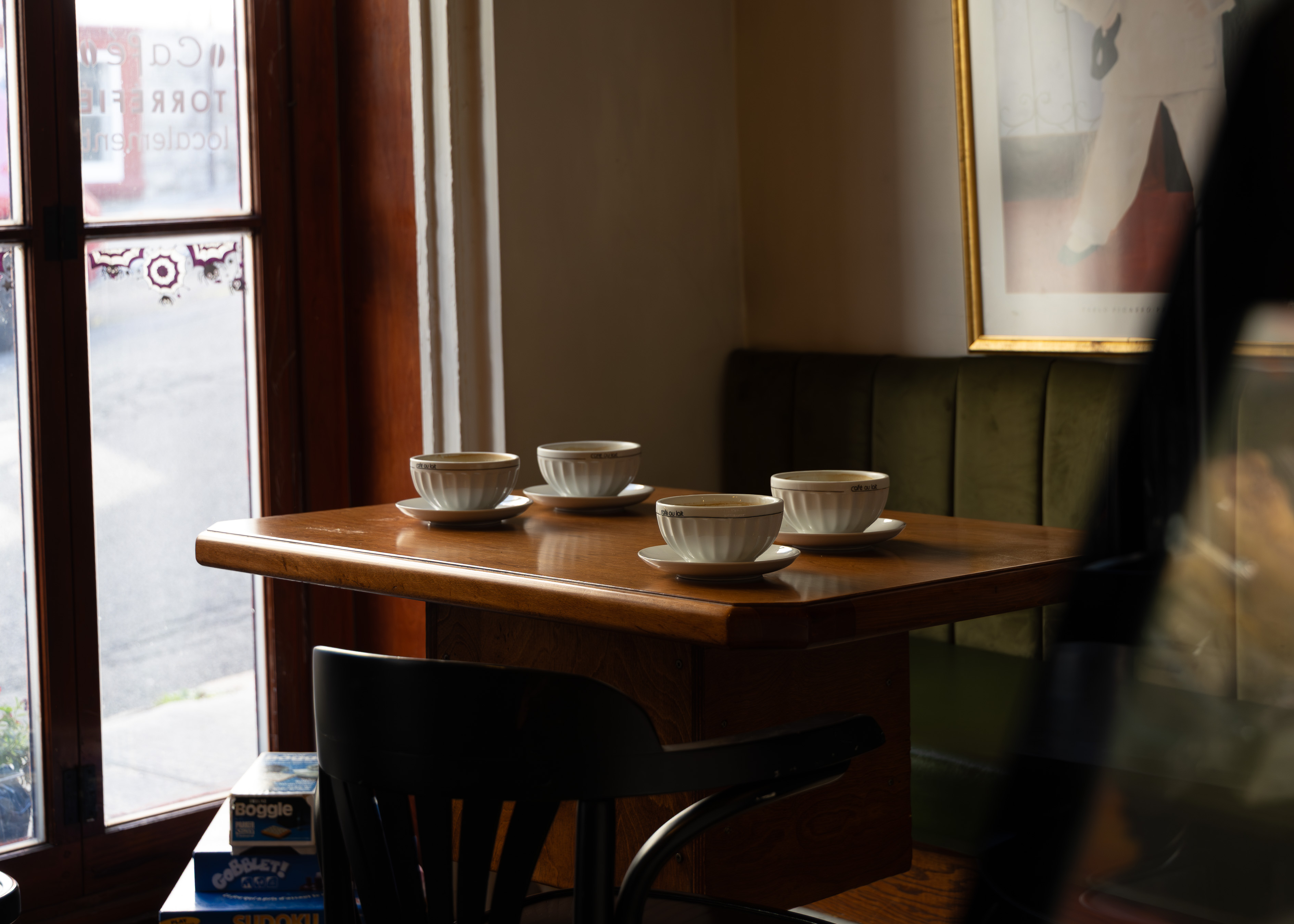 Quiet Quebec City cafe corner with empty wooden table set with four small bowls of cafe au lait